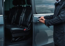 The personal driver welcoming you in the luxury transfer car.