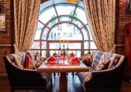 restaurant-table-with-two-couches-near-window_140725-8459